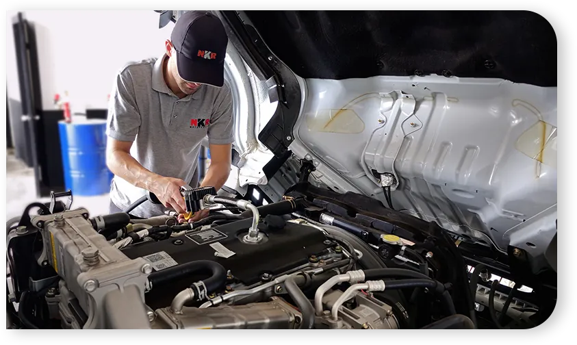 Técnico de NKR trabajando en un motor Isuzu
